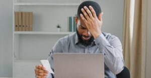 Upprörd och ledsen man med skägg som hanterar sin personliga budget på grund av personlig konkurs.