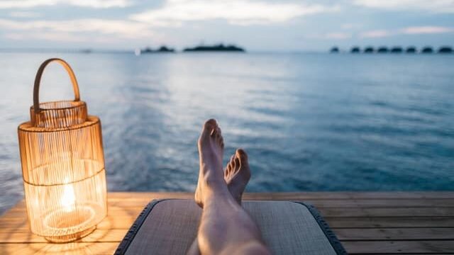 En person som låna pengar till semester och ligger och njuter nere vid havet på sin semester.
